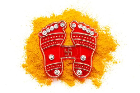 Indian Hindu religious Goddess Laxmi "Charan Paduka" (written in Hindi) is placed on turmeric (Haldi).