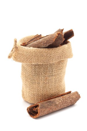 Close-up of Dry organic Cinnamon sticks (Cinnamomum verum) in a jute bag. Isolated over a white background.