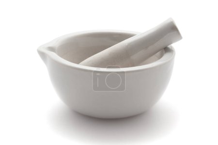 Close-up of white Ceramic Mortar and Pestle over a white background.  