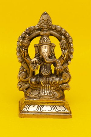Foto de La estatua del ídolo de Dios hindú hecha de material de bronce representa al Dios indio Ganpati. - Imagen libre de derechos