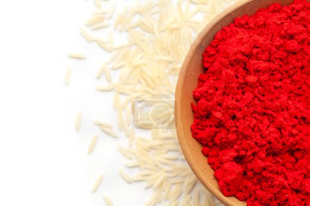 Vista superior de la olla de tierra llena de sindoor de color rojo auspicioso y arroz espolvoreado aislado sobre un fondo blanco.