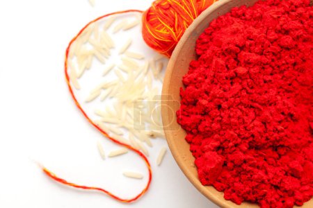 Vue du dessus du pot de terre rempli de sindoor rouge aupicieux, de riz saupoudré et de kalawa (fil de caniche). Objet pou-ja hindou sur fond blanc.