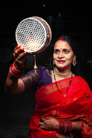 An Indian woman looking at the moon through a sieve during the Karwa Chauth festival.