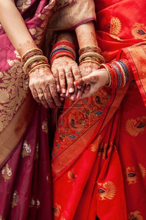 Konzept der indischen Hochzeitszeremonie. Zwei Frauen tragen Saris und zeigen ihre Armreifen bei einer indischen Hochzeitszeremonie.