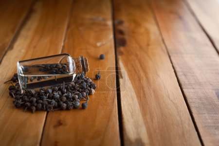 Photo for Pile of organic Sheetal Chini (Piper cubeba) seeds, and a bottle of its essential oil. - Royalty Free Image