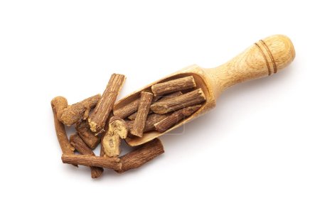 Top view of Dry Organic Liquorice or Mulethi (Glycyrrhiza glabra) roots, in a wooden scoop. Isolated on a white background.