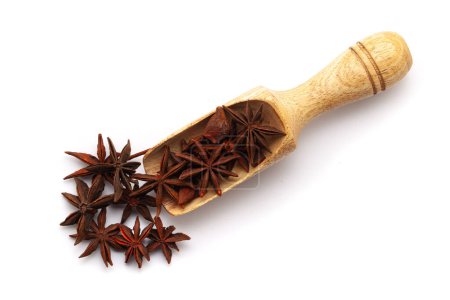 Top view of Organic Star anise or Chakra Phool (Illicium verum) in a wooden scoop. Isolated on a white background.