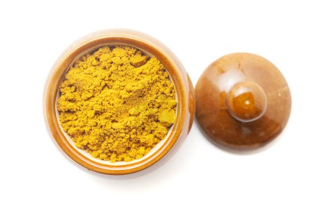 Vista superior del polvo digestivo orgánico llamado "Buknu" una mezcla de hierbas ayurvédicas indias y especias, en un frasco de cerámica. Aislado sobre un fondo blanco.