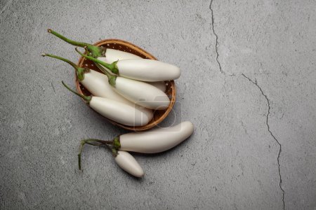 Close-up of organic white fresh Eggplant or Brinjal (Solanum melongena), isolated on a marble background.