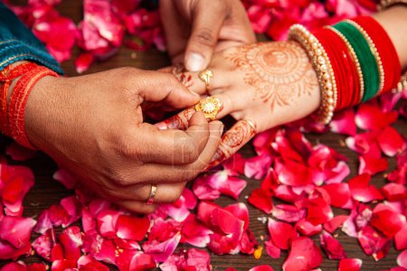 Indisches Paar tauscht während einer Hindu-Verlobungszeremonie seine Eheringe.