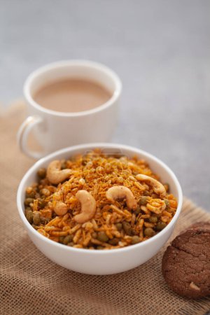 Nahaufnahme von knusprigen indischen Mixtur-Snacks mit heißem Tee oder Kaffee und handgemachten Keksen (Keksen). Studiodreh in abgesenktem Winkel. 