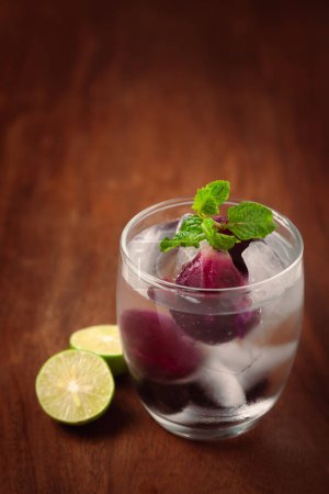 Nahaufnahme von frischem Bio-Fruchtjamun (Syzygium Cumini) Limonade mit Limette und gekühltem Wasser und Eis (Jamunsamen sind eine Art ayurvedisches Kraut gegen Diabetes