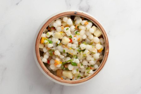 Close-up of Sabudana Khichadi - An authentic dish from Maharashtra made with sago seeds and garnished with coriander leaves served in ceramic bowl