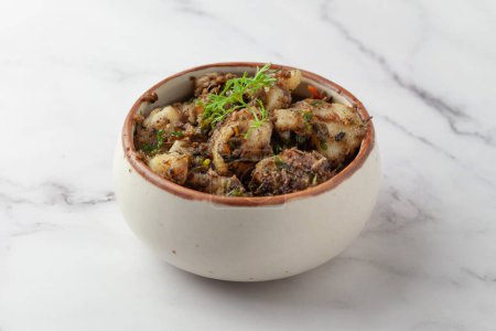 Macro Primer plano del plato clásico vegetariano indio Jeera Aloo - Patatas con sabor a comino adornado con hojas frescas de cilantro verde y chile verde. 