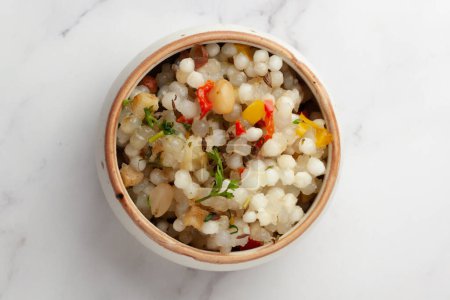 Close-up of Sabudana Khichadi - An authentic dish from Maharashtra made with sago seeds and garnished with coriander leaves served in ceramic bowl