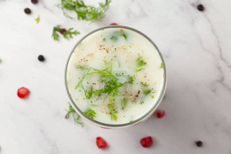 Primer plano de la bebida de verano Leche de mantequilla o mattha o vaso de Chhachh adornado con cilantro hecho con leche y cuajada. 