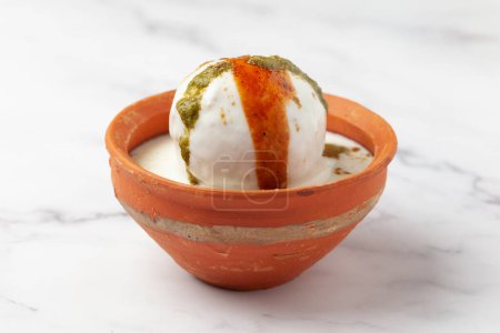 Chaat Dahi vada (AKA Dahi Bhalla, Doi Bora, mosaru vade, Dahi Bara, thayir vadai, perugu vada ). Prepared by soaking vadas in thick dahi (yogurt). Garnished with tamarind chutney sweet and  coriander spicy chutney