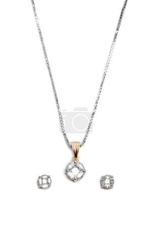 Primer plano de hermoso collar de diamantes con pendientes aislados sobre fondo blanco.