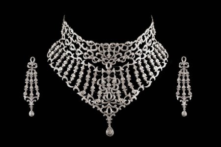 Close up of diamond necklace on black background with diamond earrings.