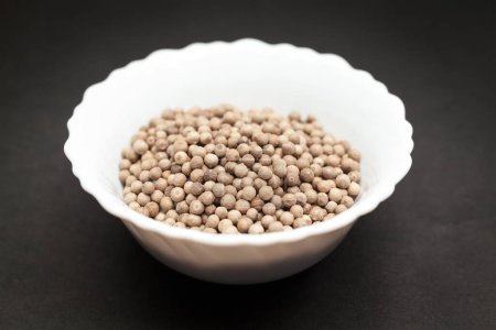 Photo for Organic White Pepper (Piper nigrum) in white ceramic bowl on dark background. - Royalty Free Image