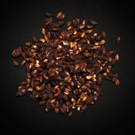 Top view of Organic Dried Pomegranate seeds (Punica granatum) isolated on dark background.
