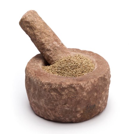 Organic Ajwain (Trachyspermum ammi) in mortar with pestle, isolated on white background.