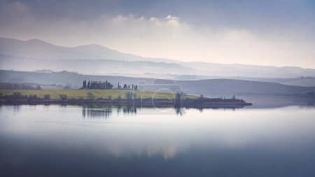 Téléchargez les photos : Vue sur le lac Santa Luce par une matinée brumeuse bleue. Colline Pisane, Toscane, Italie - en image libre de droit