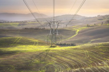 Téléchargez les photos : Tour de transmission électrique qui supporte une ligne électrique aérienne dans le paysage toscan. Italie - en image libre de droit