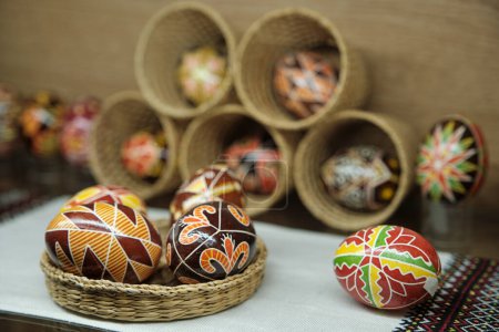 Téléchargez les photos : Œufs de Pâques colorés peints à la main dans un bol en osier. Œufs décorant dans la culture slave. Bel oeuf de Pâques ukrainien Pysanky. - en image libre de droit