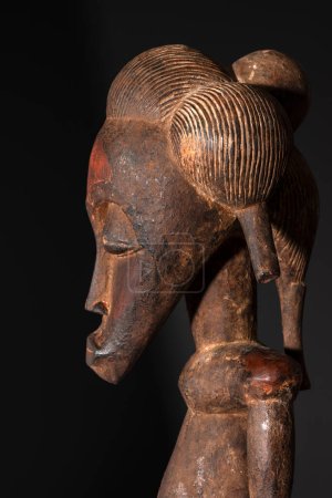 Close up of a wooden Senufo Male figure from Ivory Coast. Tribal African art, showcasing masterful craftsmanship and spiritual symbolism.