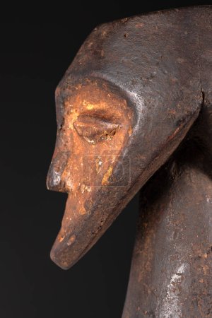 Großaufnahme einer männlichen Figur, schöne schwarze Patina und Kaolinpigmente, isoliert auf schwarz. Afrikanische Stammeskunst mit meisterhafter Handwerkskunst und spiritueller Symbolik.