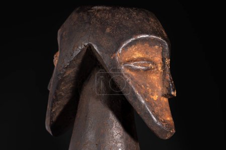 Großaufnahme einer zweiköpfigen männlichen Figur, schöne schwarze Patina und Kaolinpigmente, isoliert auf schwarz. Afrikanische Stammeskunst mit meisterhafter Handwerkskunst und spiritueller Symbolik.