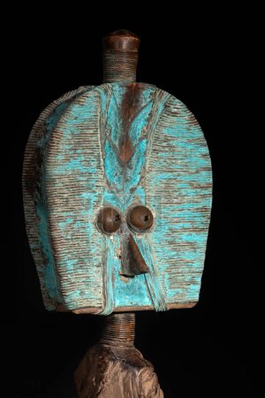 Close up of a wooden Kota reliquary figure from Gabon, isolated on a black background. Tribal African art, showcasing masterful craftsmanship and spiritual symbolism.