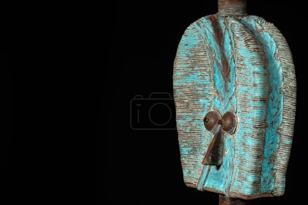 Primer plano de una figura relicaria Kota de madera de Gabón, aislada sobre un fondo negro. Arte africano tribal, mostrando la maestría artesanal y el simbolismo espiritual.