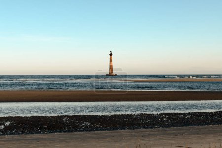 Morris Island Lighthouse from the shoreline of Folly Beach near Charleston, South Carolina.