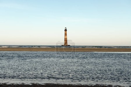 Morris Island Lighthouse from the shoreline of Folly Beach near Charleston, South Carolina.