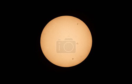 Foto der Sonne, wo man die Internationale Raumstation ISS und Sonnenflecken sehen kann