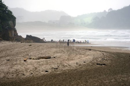 Photo for Hot water Beach, Whitianga, New Zealand - 10th November 2022:Families enjoying the hot water on a cold wet day - Royalty Free Image