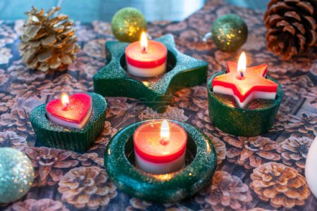 Photo for Christmas candle holder for tea lights made of plaster with burning candles. Handmade in green with glitter dust. - Royalty Free Image