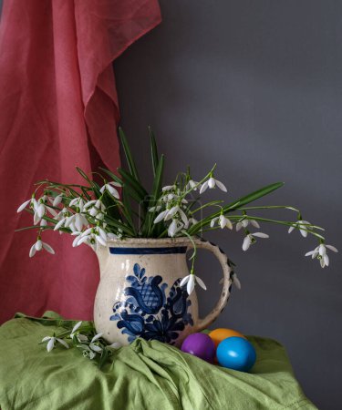 Un arreglo de naturaleza muerta de huevos de Pascua, flores de primavera. Bodegón con gotas de nieve y eags éster.