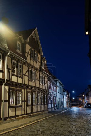 Foto de Bleicherode, Alemania - 17 08 2023: Callejón de la calle en el pequeño pueblo de Schwabisch Hall, con casas y edificios con arquitectura típica alemana y faroles de la calle, por la noche. - Imagen libre de derechos