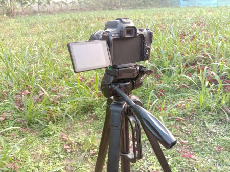 Photo for Black colored DSLR camera with try pod and nature - Royalty Free Image