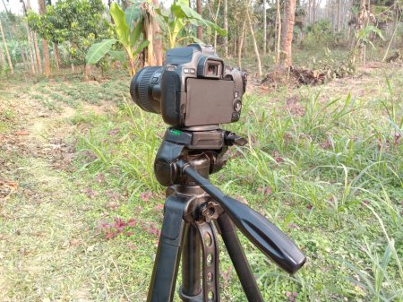Photo for Black colored DSLR camera with try pod and nature - Royalty Free Image