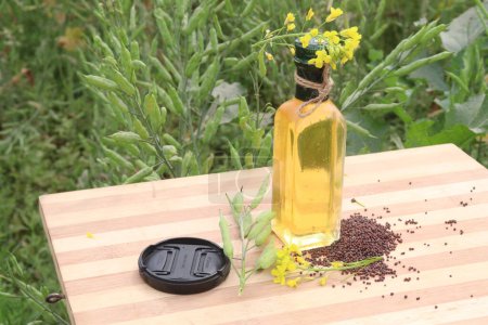 aceite de mostaza en botella con flor y brote y semillas en la granja para la cosecha son cultivos comerciales
