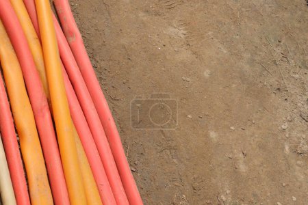 Photo for A Background of multiple colored plastic pipe and soil floor for any use - Royalty Free Image