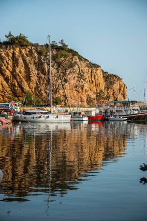 Small boats and yachts docked on the marina park with oceanfront view in Greece.