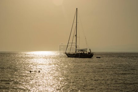 Pequeños barcos y yates al atardecer atracados en el parque deportivo con vista al mar en Grecia.