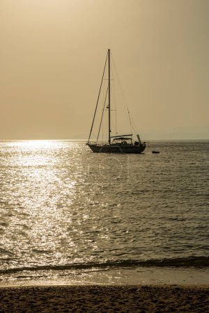 Kleine Boote und Yachten bei Sonnenuntergang im Yachthafenpark mit Meerblick in Griechenland.