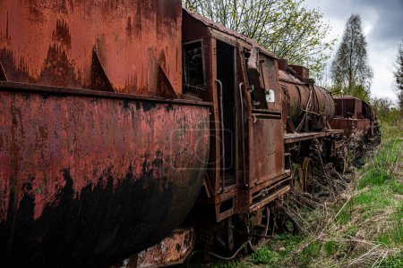 Téléchargez les photos : Locomotive à vapeur rouillée avec wagon de charbon abandonné au cimetière des trains sur une ancienne voie ferrée. - en image libre de droit