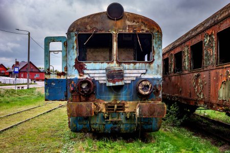 Téléchargez les photos : Ancien train-bloc électrique rouillé déclassé et abandonné sur la voie d'évitement du chemin de fer sur un champ herbeux vert - en image libre de droit